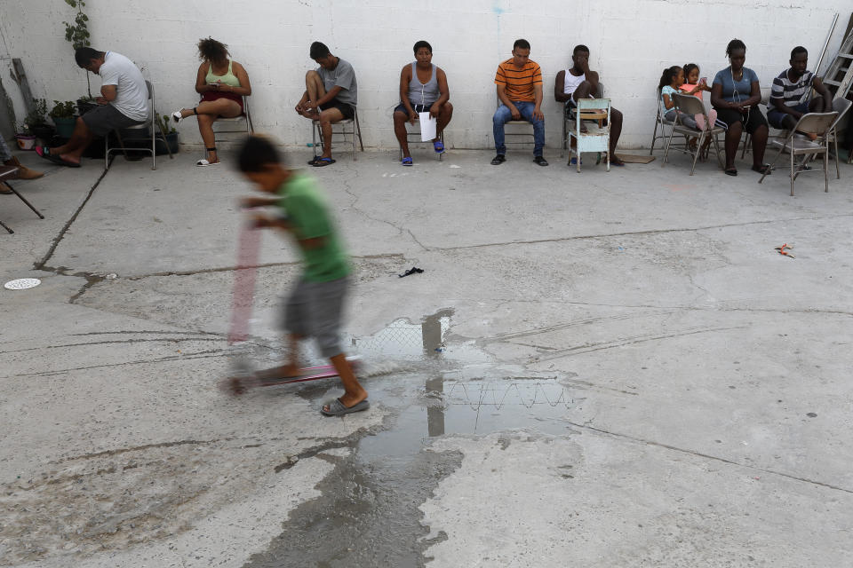 In this July 26, 2019, photo, people from Africa and Central America sit in chairs as the sun sets at El Buen Pastor shelter for migrants in Cuidad Juarez, Mexico. (AP Photo/Gregory Bull)