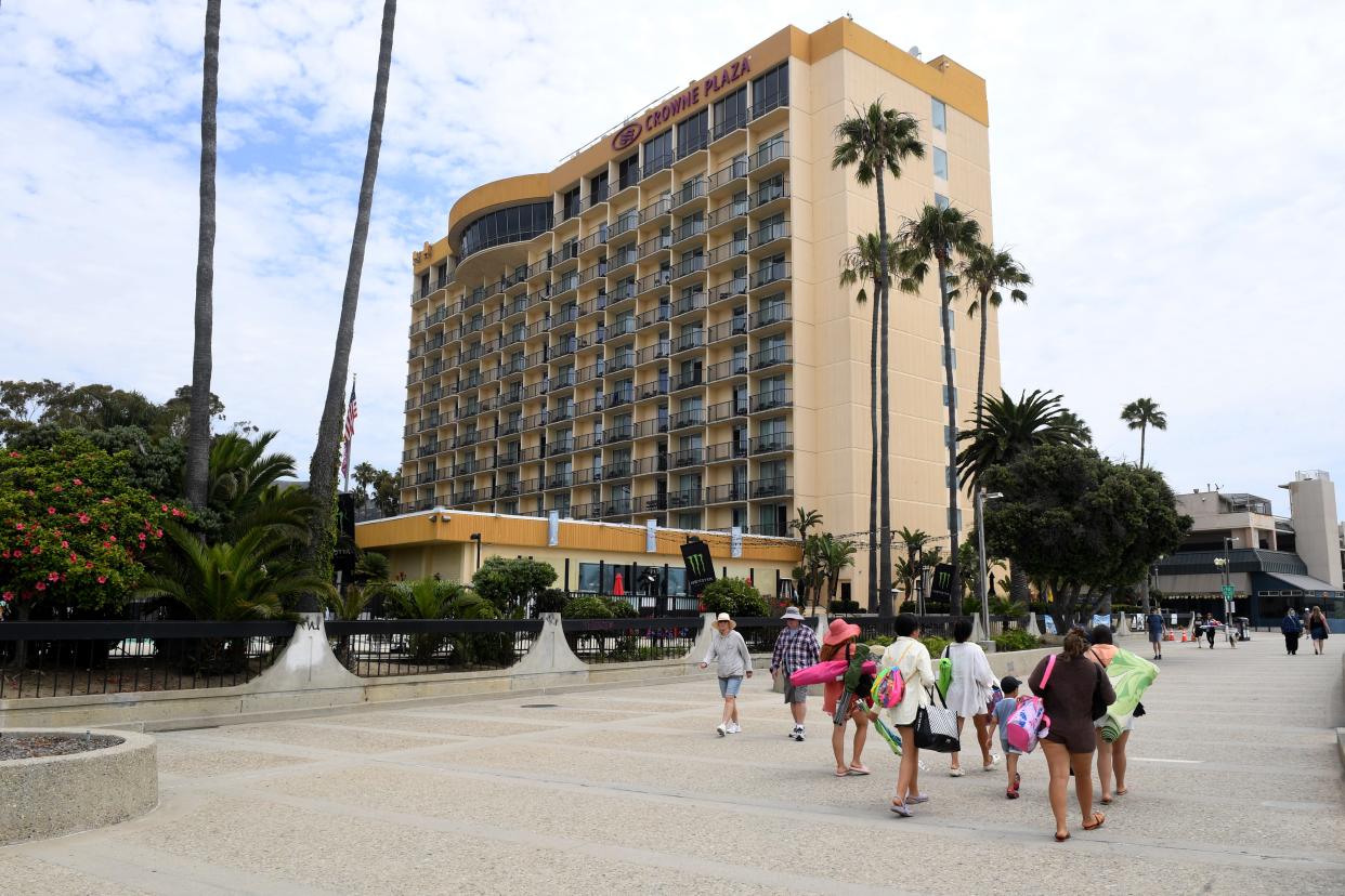 Visitors walk along the Ventura Promenade near the Crowne Plaza Hotel on July 17.