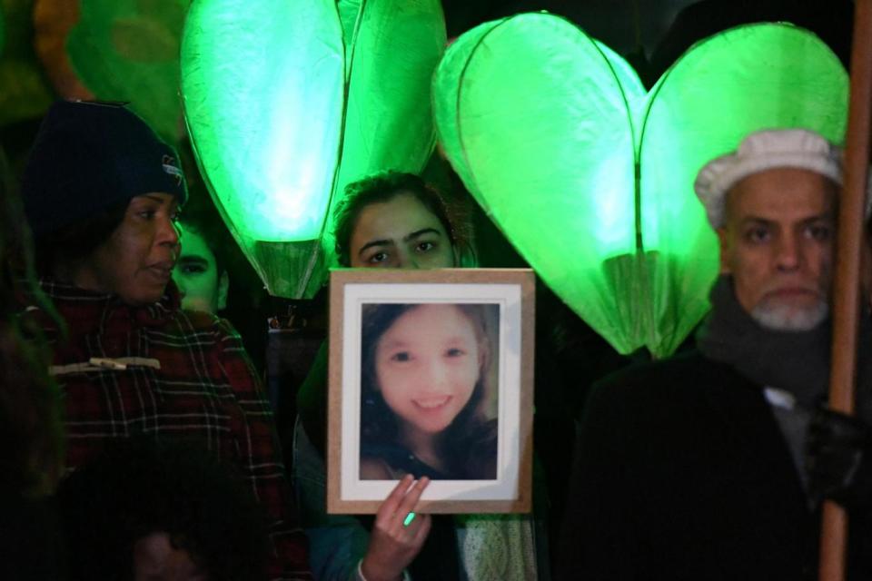 Marchers carried green candles, flowers and pictures of loved ones who died in the fire (REUTERS)