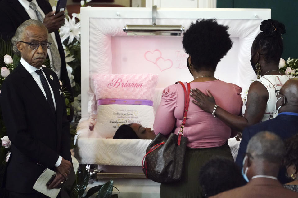 Rev. Al Sharpton, left, stands next to the casket as people file past during a funeral service for Brianna Grier Thursday, Aug. 11, 2022, in Atlanta. The 28-year-old Georgia woman died after she fell from a moving patrol car following her arrest. (AP Photo/John Bazemore)