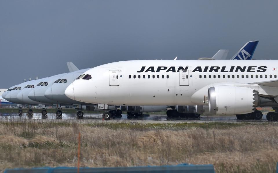 A Japan Airlines (JAL) passenger plane (front) sits on the tarmac at Tokyo's Haneda airport (AFP via Getty Images)