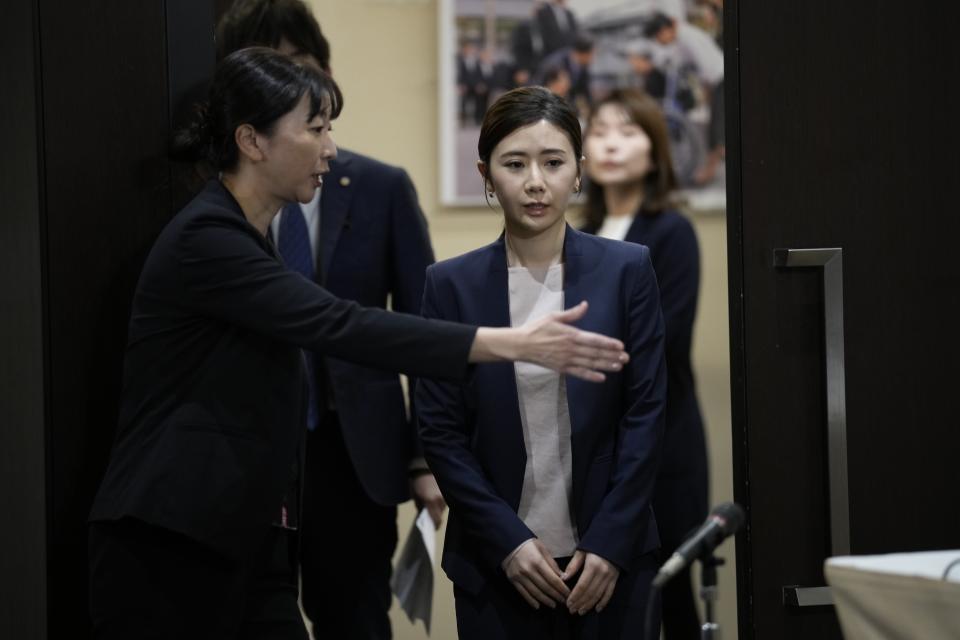 Former Japanese table tennis player and Olympic medallist Ai Fukuhara is guided to the venue to make a brief statement during a news conference about a child-custody agreement she forged with ex-husband Chiang Hung-chieh of Taiwan at the Foreign Correspondents' Club of Japan (FCCJ) Friday, March 15, 2024, in Tokyo. (AP Photo/Eugene Hoshiko)