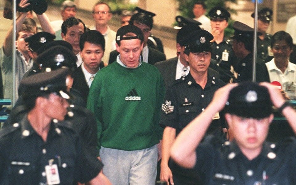 Rogue financial trader Nick Leeson arrives at Singapore's Changi airport surrounded by police - John MACDOUGALL / AFP