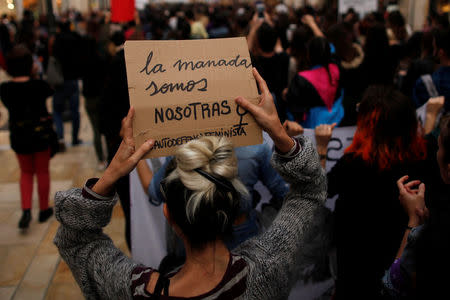 People take part in a protest after a Spanish court condemned five men accused of the group rape of an 18-year-old woman, in Malaga, Spain, April 26, 2018. The placard reads: "The wolf pack are us". REUTERS/Jon Nazca