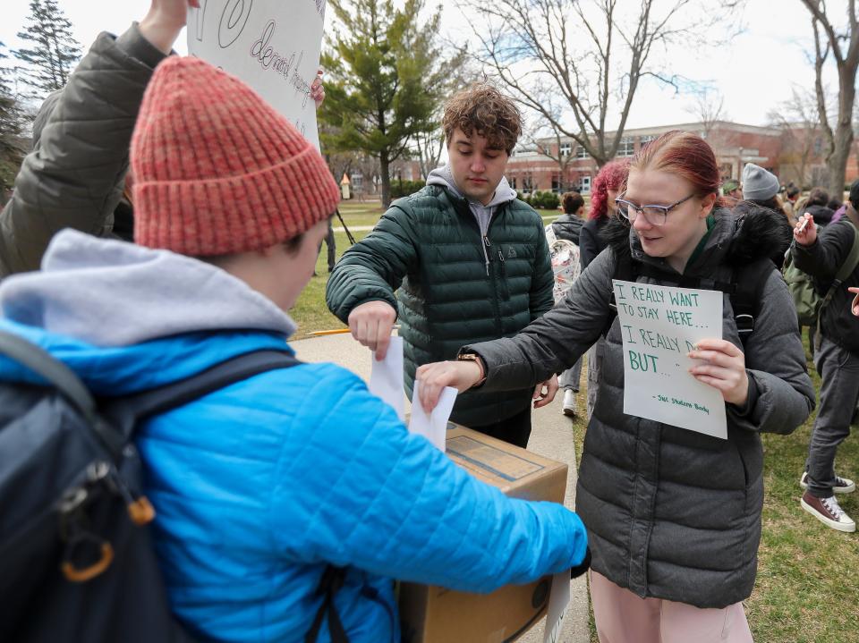 St. Norbert student Lauren Weigel, right, puts a suggestion form into a collection box during a protest on Wednesday at the college.