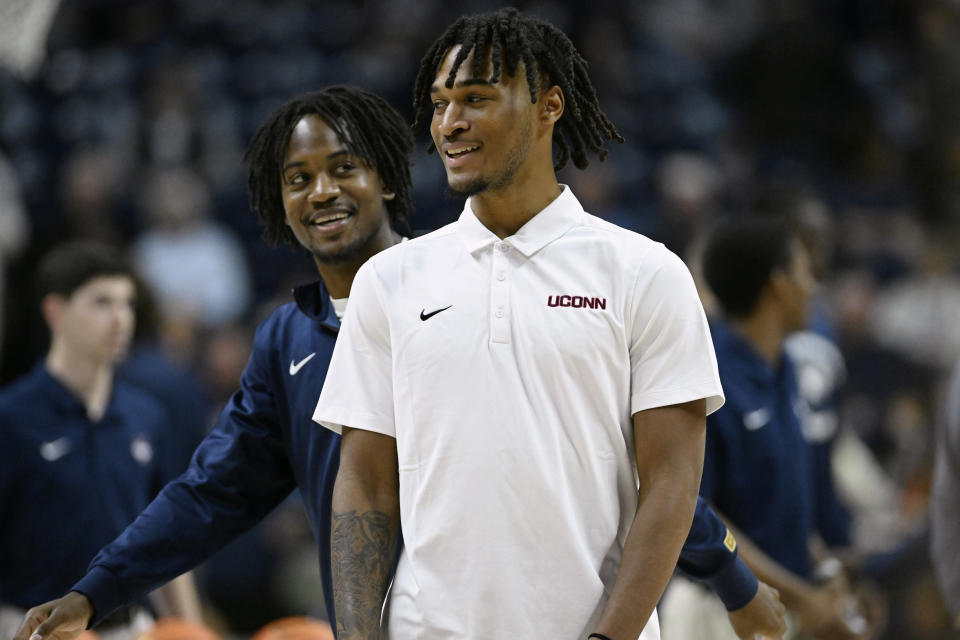 UConn guard Stephon Castle, center, smiles as teammate guard Tristen Newton walks behind him as the team warms up before an NCAA college basketball game against New Hampshire, Monday, Nov. 27, 2023, in Storrs, Conn. (AP Photo/Jessica Hill)