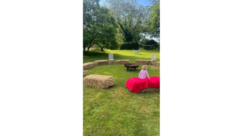 A photo of Romy sitting on a hay bale