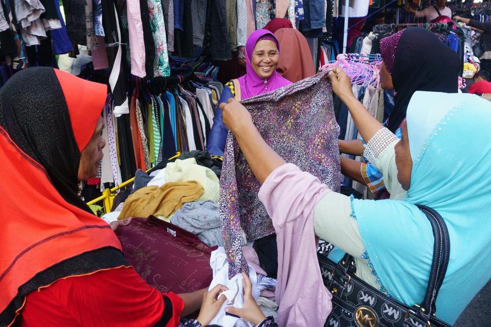 A few Malaysian women buying clothes at a thrift store