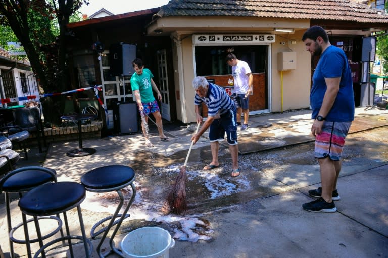 A man cleans up the ground at a cafe after a man shot dead five people in the village of Zitiste, northern Serbia, on July 2, 2016