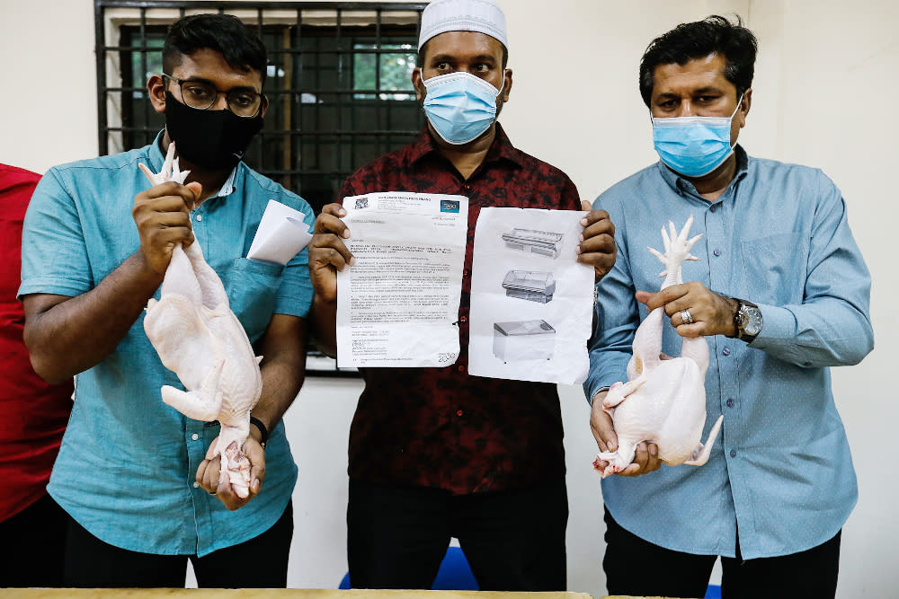 Penang Traders Association Chairman Azizurahman A. Dzulkarnain (centre) and association members show the difference between slaughtered (left) and frozen (right) chicken in Penang January 11, 2021. — Picture by Sayuti Zainudin