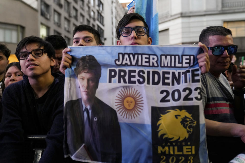 Simpatizantes sostienen una pancarta del candidato presidencial de la oposición Javier Milei afuera de su sede de campaña tras el cierre de las urnas en la segunda vuelta presidencial en Buenos Aires, Argentina, el domingo 19 de noviembre de 2023. (AP Foto/Natacha Pisarenko)