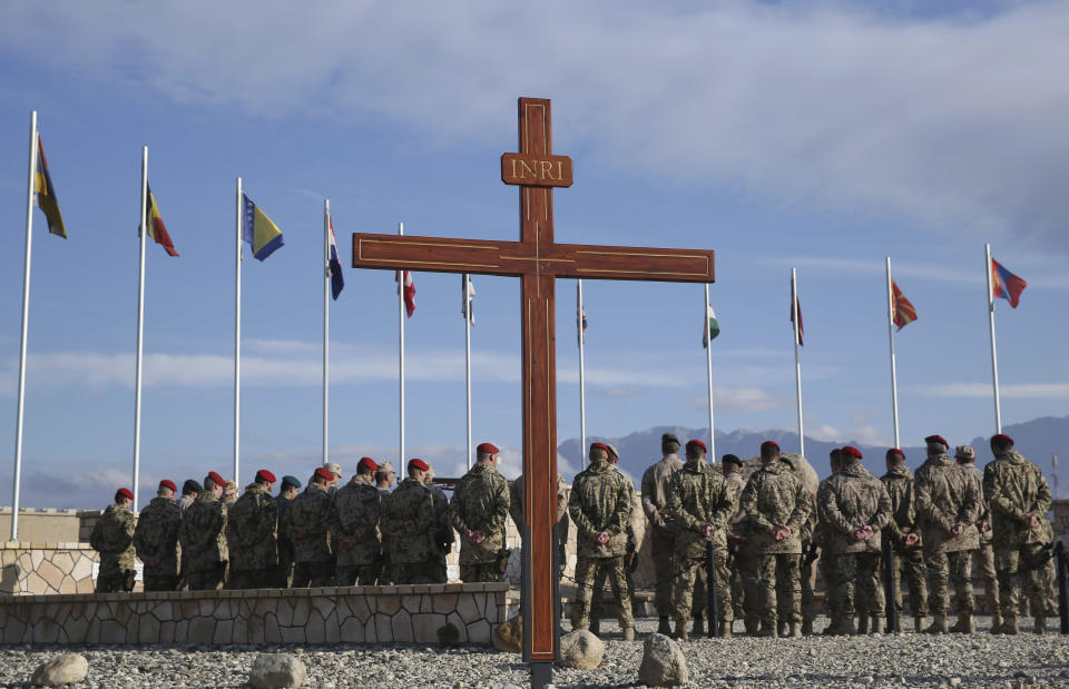 FILE - In this, Nov. 7, 2014 file photo, German soldiers participate in a memorial ceremony recalling those killed on allied missions, during a visit by NATO Secretary General Jens Stoltenberg, at the German NATO base, Camp Marmal, Mazar-i Sharif, Afghanistan. After 20 years of military engagement and billions of dollars spent, NATO and the United States still grapple with the same, seemingly intractable conundrum — how to withdraw troops from Afghanistan without abandoning the country to even more mayhem. Currently, 2,500 U.S. and about 10,000 NATO troops are still in Afghanistan. (AP Photo/Massoud Hossaini, File)