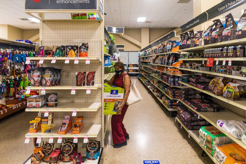 Elsa Romero buys supplies for her three dogs at a pet store in Miami.