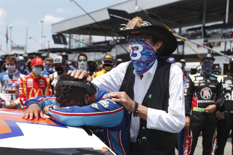 NASCAR driver Bubba Wallace is consoled by team owner Richard Petty, right, prior to the start of the NASCAR Cup Series at the Talladega Superspeedway in Talladega, Ala., Monday, June 22, 2020. In an extraordinary act of solidarity with Wallace, NASCAR's only Black driver, dozens of drivers pushed his car to the front of the field before Monday's race. (AP Photo/John Bazemore)