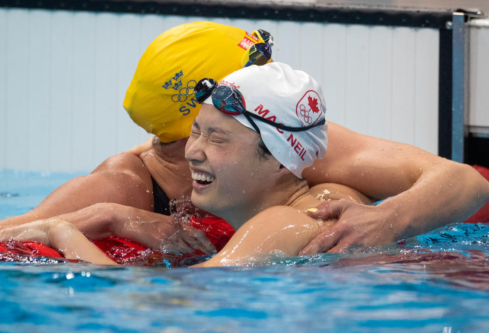 <p>Canada's Margaret MacNeill receives a big hug from Sweden's Sarah Sjoestroem after grabbing gold in the 100m Butterfly for Women at the Tokyo Aquatic Centre on July 26.</p>