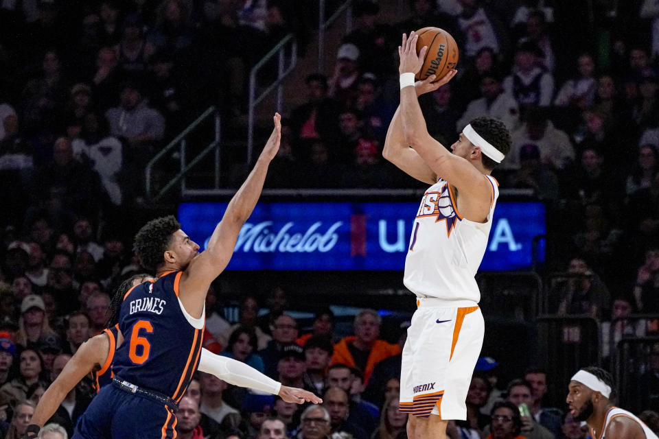 Phoenix Suns guard Devin Booker (1) shoots over New York Knicks guard Quentin Grimes (6) during the second half of an NBA basketball game in New York, Sunday, Nov. 26, 2023. (AP Photo/Peter K. Afriyie)