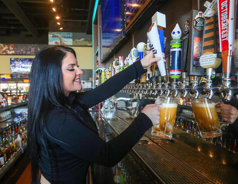 On Tap Grille & Bar bartender Coco Lukacs pours a draft beer from one of the 43 taps at the Medina location.