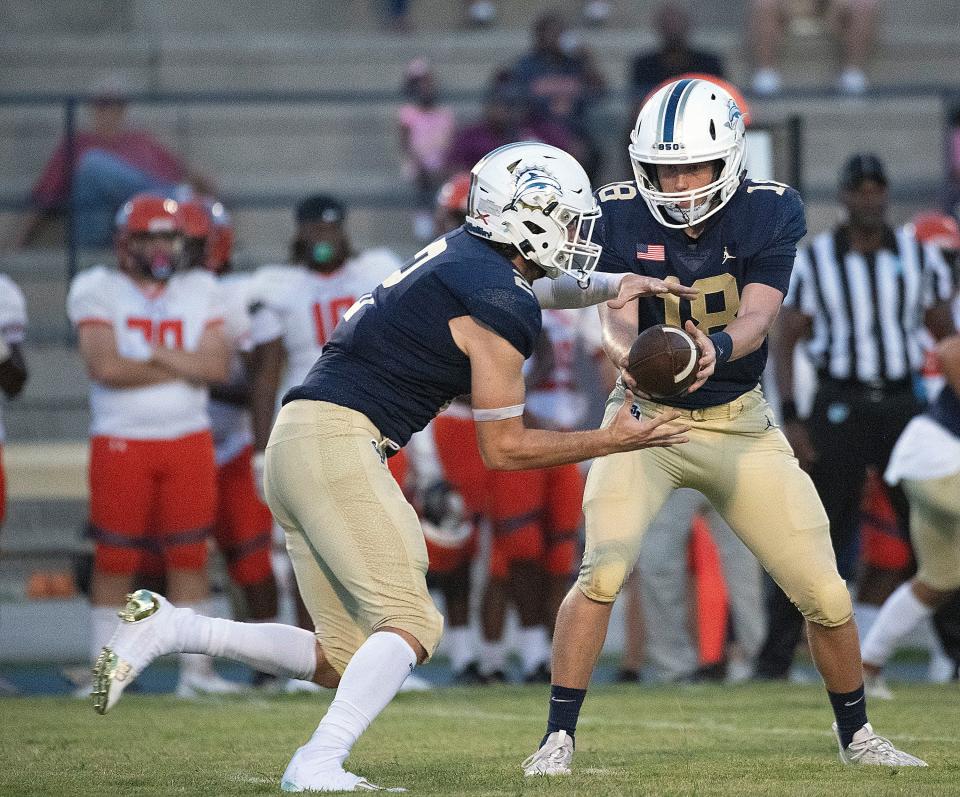 Gulf Breeze quarterback Battle Alberson (No. 18) hands off to Jake Frazetta (No.2) as the pair work to get the ground game working during Friday's game against Escambia.