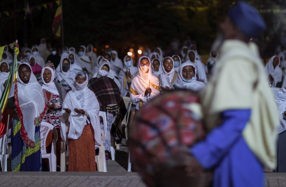 Ethiopian Orthodox Christians light candles and pray for peace during a church service at the Medhane Alem Cathedral in the Bole Medhanealem area of the capital Addis Ababa, Ethiopia Thursday, Nov. 5, 2020. Ethiopia's powerful Tigray region asserts that fighter jets have bombed locations around its capital, Mekele, aiming to force the region "into submission," while Ethiopia's army says it has been forced into an "unexpected and aimless war." (AP Photo/Mulugeta Ayene)