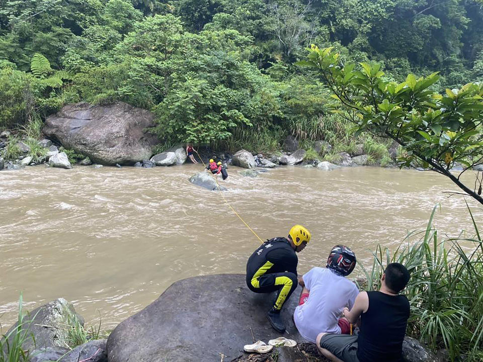 新北市三峽區23日下午下起大雨，2名女移工因大豹溪溪水暴漲受困河岸，警消獲報到場利用拋繩槍將繩索打到對岸，順利救出2人。（圖／警消提供）