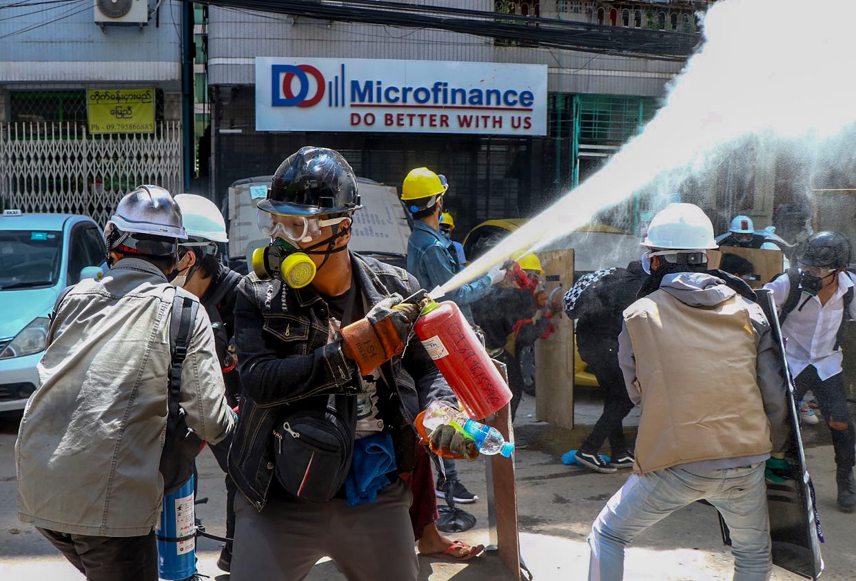 Anti-coup protesters discharge fire extinguishers to counter the impact of tear gas fired by police during a demonstration in Yangon, Myanmar, on Thursday. 