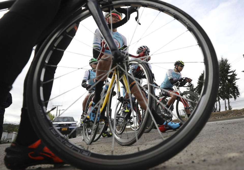 Members of the Esteban Chaves Foundation cycling team wait for time trial training in Puente Piedra near in Bogota, Colombia, Friday, Sept. 13, 2019. Although the team members must comply with mandatory doping tests, most Colombian cyclists can dope without breaking the law. The sale and traffic of performance enhancing drugs is legal in Colombia, meaning substances such as EPO can be bought over the counter. (AP Photo/Fernando Vergara)