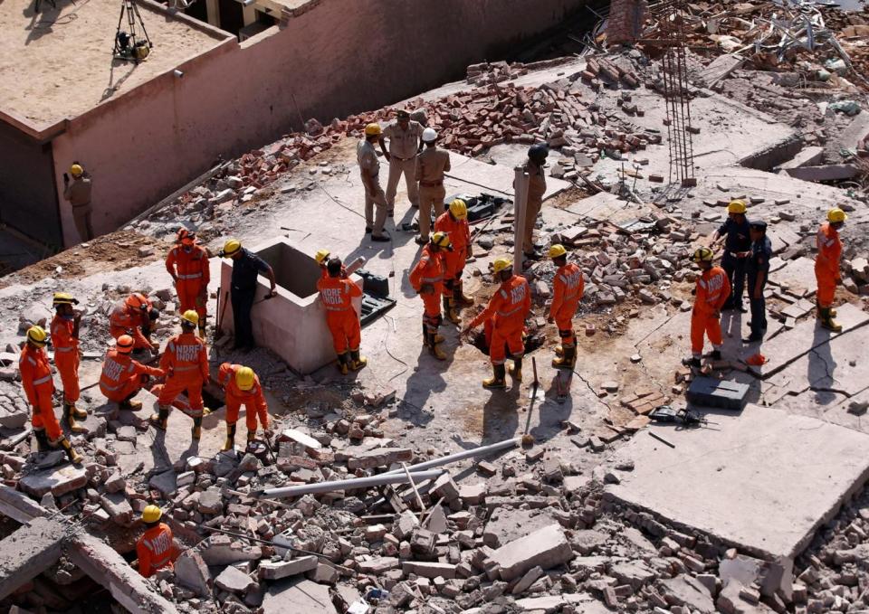 Desperate search: Rescue workers hunt for survivors in the rubble (REUTERS)