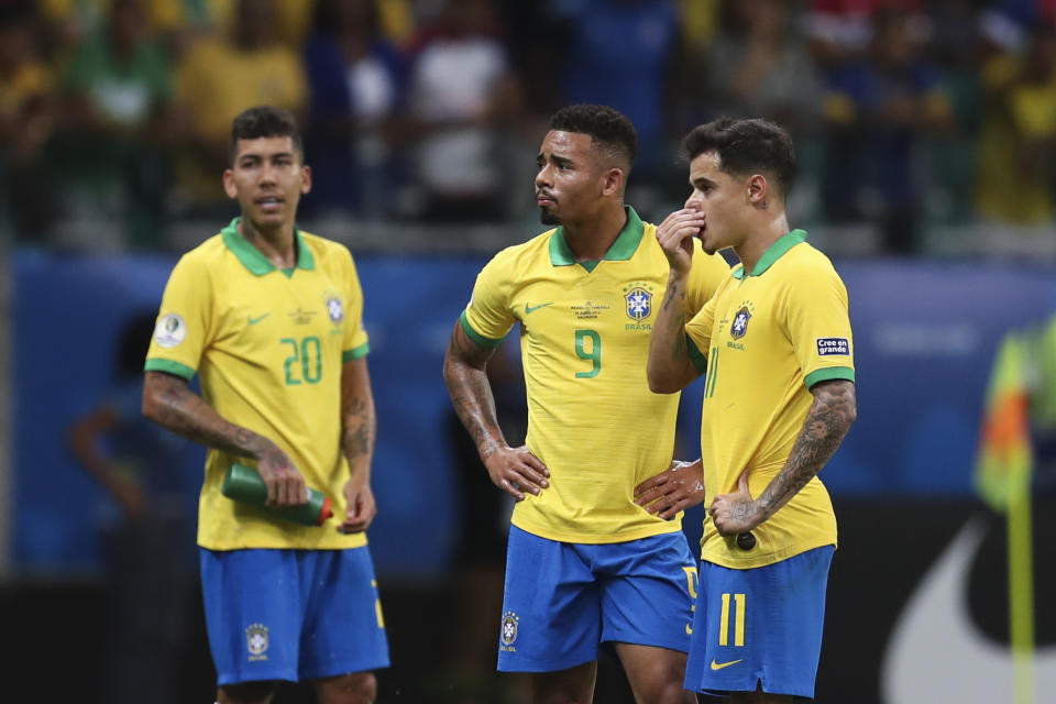 Brazil's Gabriel Jesus, center, waits for the referee to decide on his goal with teammates Brazil's Roberto Firmino, left, and Brazil's Philippe Coutinho, right, during a Copa America Group A soccer match at the Arena Fonte Nova in Salvador, Brazil, Tuesday, June 18, 2019. Referee Julio Bascunan, not in picture, annulled Gabriel Jesus' goal due to an offside position. (AP Photo/Natacha Pisarenko)