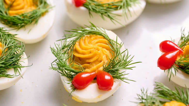 deviled eggs with dill wreaths and pepper bow on plate