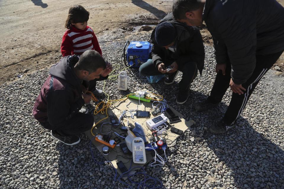 Displaced Iraqis, who fled fighting between Iraqi security forces and Islamic State militants, wait to charge their mobile phones and electrical lanterns, the generator owner charging 500 Iraqi dinars (about 45 U.S. cents) to charge each mobile phone, at Sewdinan Camp for the displaced near Khazer, Iraq on Tuesday, Jan. 3, 2017. Displaced by the fighting in Mosul, Iraqis who escaped Islamic State rule in the northern Iraqi city are doing something they had not done in more than two years: Speaking publicly on their mobile phones and using social media to communicate with friends, relatives and loved ones (AP Photo/ Khalid Mohammed)