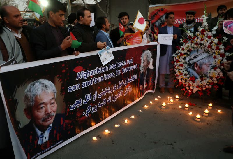 Afghan men light candles for Japanese doctor Tetsu Nakamura, who was killed in Jalalabad in yesterday's attack, in Kabul