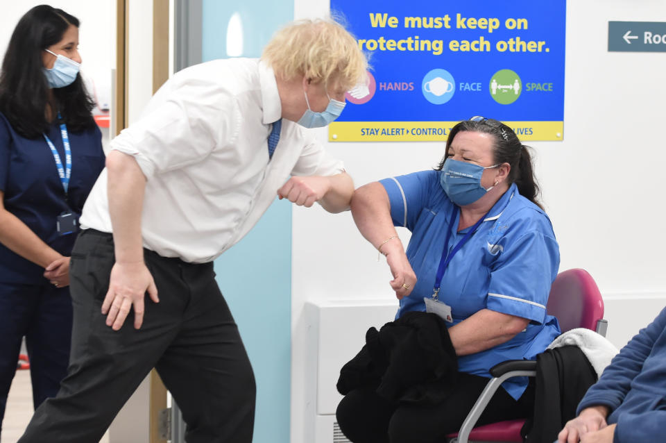 Britain's Prime Minister Boris Johnson (L) greets nurse Michelle Bradford (R) at the coronavirus vaccination hub at the Health and Well-being Centre in Orpington, southeast London on February 15, 2021. - Prime Minister Boris Johnson called Britain hitting a target of inoculating 15 million of the most vulnerable people with a first coronavirus jab 