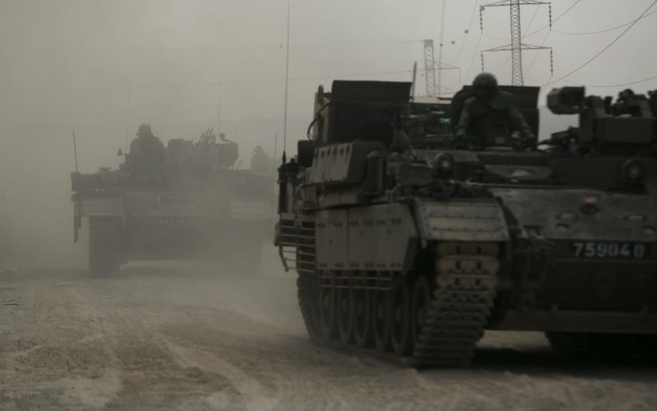 NEAR SDEROT, ISRAEL - OCTOBER 14: Israeli armor personnel carrier move in formation near the border with Gaza on October 14, 2023 in Near Sderot, Israel. Israel has sealed off Gaza and launched sustained retaliatory air strikes, which have killed at least 1,400 people with more than 400,000 displaced, after a large-scale attack by Hamas. On October 7, the Palestinian militant group Hamas launched a surprise attack on Israel from Gaza by land, sea, and air, killing over 1,300 people and wounding around 2,800. Israeli soldiers and civilians have also been taken hostage by Hamas and moved into Gaza. The attack prompted a declaration of war by Israeli Prime Minister Benjamin Netanyahu and the announcement of an emergency wartime government. (Photo by Amir Levy/Getty Images)