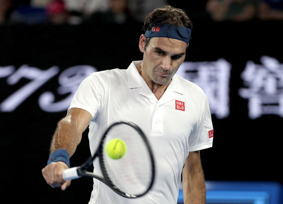 Switzerland's Roger Federer makes a backhand return to United States' Taylor Fritz during their third round match at the Australian Open tennis championships in Melbourne, Australia, Friday, Jan. 18, 2019. (AP Photo/Kin Cheung)