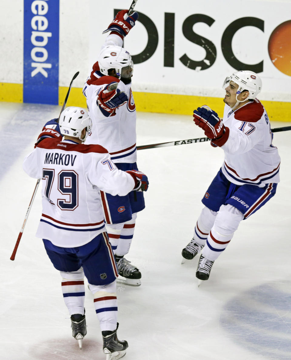 Montreal Canadiens defenseman P.K. Subban, center, raises his arms after scoring the game-winning goal off Boston Bruins goalie Tuukka Rask during the second overtime period of Game 1 in the second round of the Stanley Cup playoffs in Boston, Thursday, May 1, 2014. The Canadiens won 4-3. At left is defenseman Andrei Markov and at right is left wing Rene Bourque. (AP Photo/Charles Krupa)