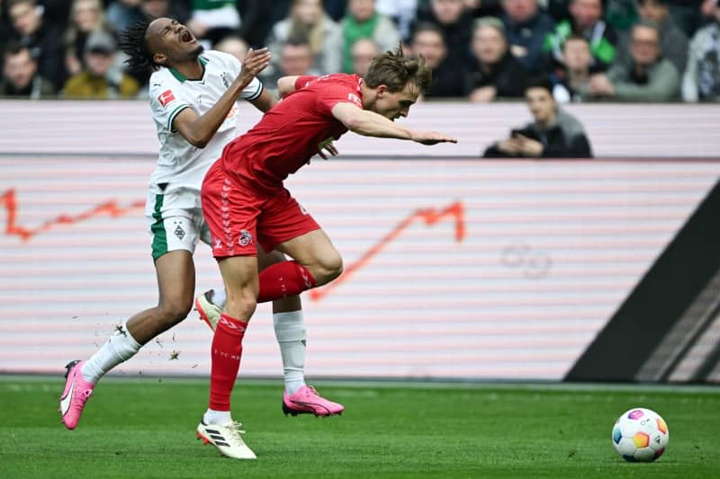 Moenchengladbach's Nathan Ngoumou (L) and Cologne's Timo Huebers battle for the ball during the German Bundesliga Soccer match between Borussia Moenchengladbach and 1. FC Colone at the Borussia-Park. Federico Gambarini/dpa