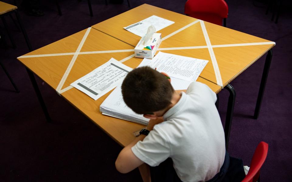 Social distancing measures are enforced as a child studies at a marked table at Kempsey Primary School in Worcester - PA