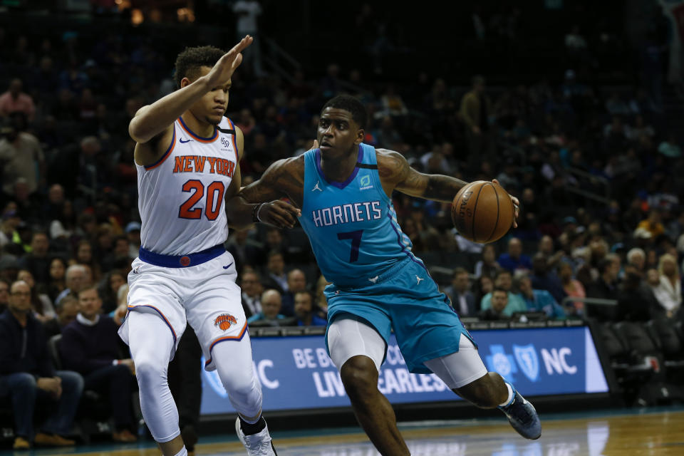 Charlotte Hornets guard Dwayne Bacon, right, drives into New York Knicks forward Kevin Knox II in the first half of an NBA basketball game in Charlotte, N.C., Tuesday, Jan. 28, 2020. (AP Photo/Nell Redmond)