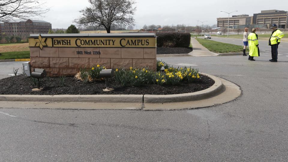 An Overland Park police officer and Kansas State Trooper guard the entrance of the Jewish Community Center after reports of a shooting in Overland Park, Kan., Sunday, April 13, 2014. (AP Photo/Orlin Wagner)