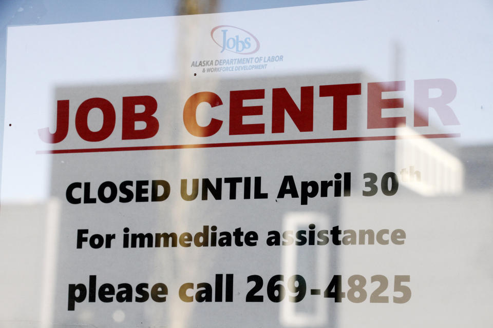 In this March 30, 2020 photo, a sign saying that the Jobs Center at the Alaska Department of Labor and Workforce Development office in midtown Anchorage, Alaska, is closed through the end of April is shown. About half of all working Americans say they or a member of their household have lost some kind of income due to the coronavirus pandemic, with low-income Americans and those without college degrees especially likely to have lost a job. That's according to a new poll from The Associated Press-NORC Center for Public Affairs Research. (AP Photo/Mark Thiessen)