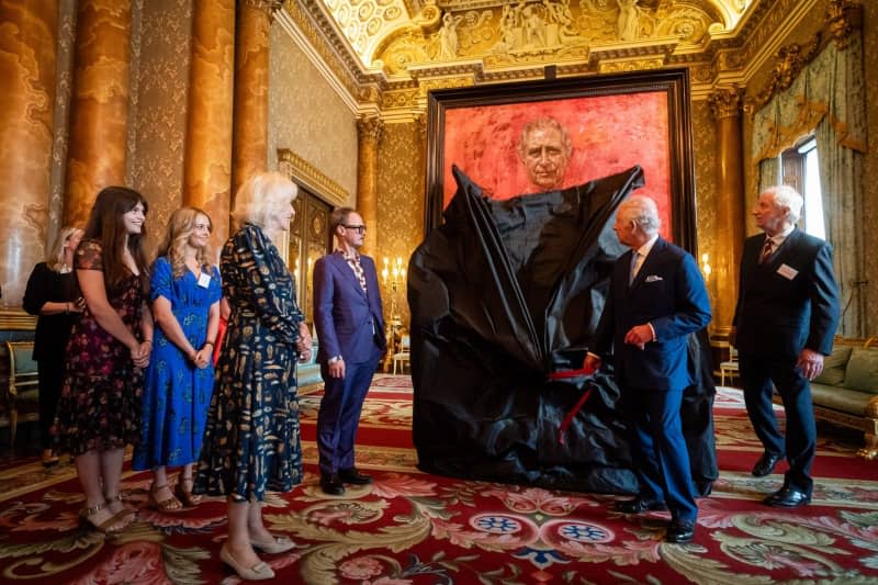 UK King Charles III unveils his portrait painting by artist Jonathan Yeo (3rd R) in the presence of Queen Camilla in the Blue Drawing Room at Buckingham Palace. Aaron Chown/PA Wire/dpa