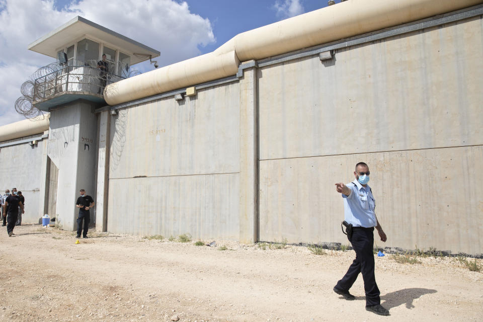 Police officers and prison guards inspect the scene of a prison escape outside the Gilboa prison in northern Israel, Monday, Sept. 6, 2021. Israeli forces on Monday launched a massive manhunt in northern Israel and the occupied West Bank after several Palestinian prisoners escaped overnight from the high-security facility in an extremely rare breakout. (AP Photo/Sebastian Scheiner)