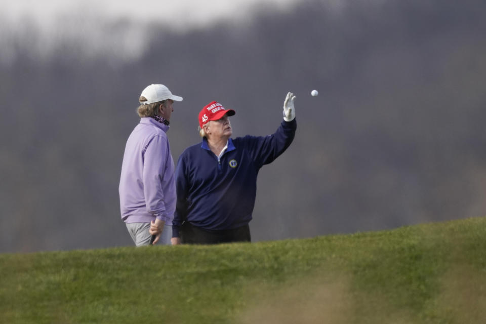 President Donald Trump is tossed a golf ball as he golfs at Trump National Golf Club in Sterling, Va., Sunday, Dec. 13, 2020. (AP Photo/Manuel Balce Ceneta)