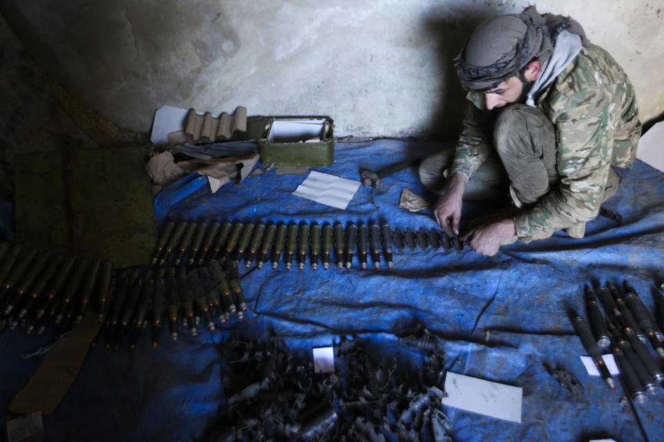 Turkish backed Syrian fighter loads ammunition at a frontline near the town of Saraqib in Idlib province, Syria, Wednesday, Feb. 26, 2020. Syrian government forces have captured dozens of villages, including major rebel strongholds, over the past few days in the last opposition-held area in the country's northwest. (AP Photo/Ghaith Alsayed)