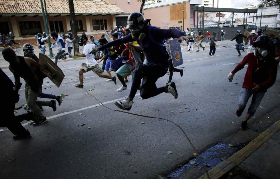 <p>Anti-Regierungs-Demonstranten rennen am ersten Tag eines 48-Stunden-Streiks im venezolanischen Caracas vor Beamten der venezolanisch-bolivarischen Nationalwache davon. Die Proteste richten sich gegen den Plan des venezolanischen Präsidenten Nicolás Maduro, aufgrund von Venezuelas politischer Lage und Wirtschaftskrise eine Verfassungsänderung zu erreichen. (Bild: AP Photos/Ariana Cubillos) </p>