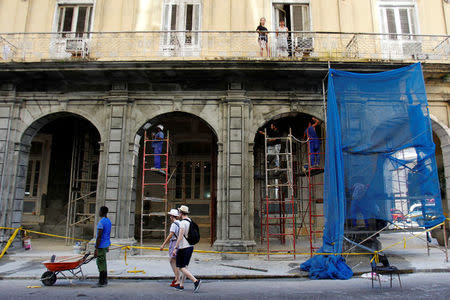 Tourists walk next to building being renovated, in Havana, Cuba July 21, 2018. REUTERS/Stringer
