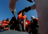 Rescuers of the Malta-based NGO Migrant Offshore Aid Station (MOAS) rescue migrants from a rubber dinghy in the central Mediterranean in international waters some 15 nautical miles off the coast of Zawiya in Libya, April 14, 2017. REUTERS/Darrin Zammit Lupi