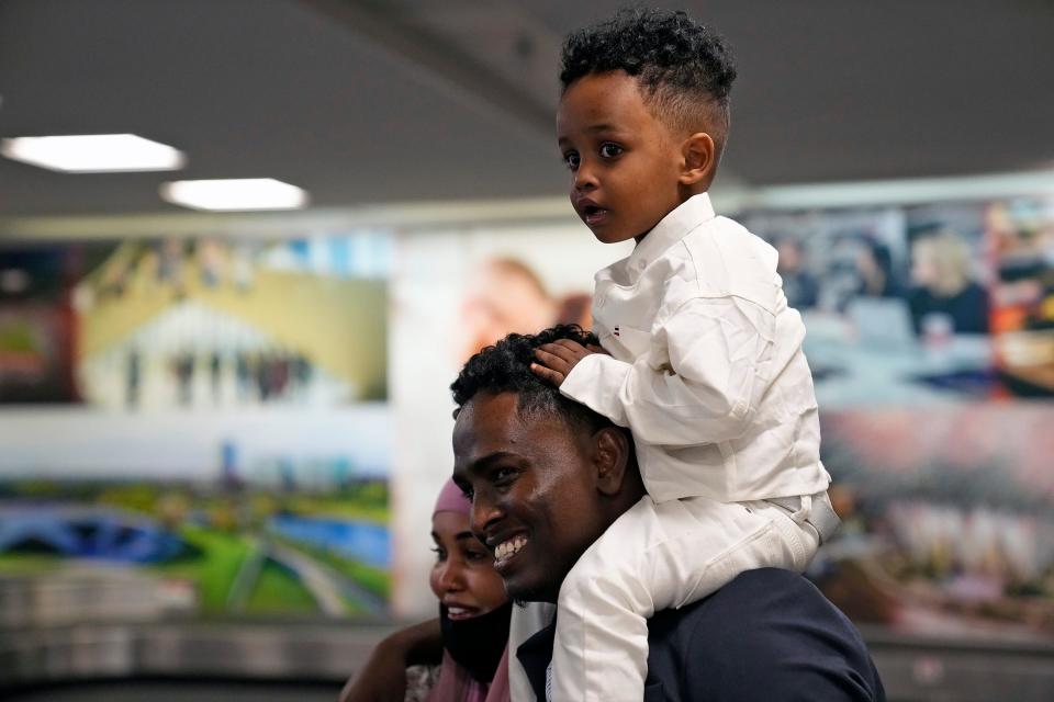Afkab Hussein smiles as he carries his son Zain, 2, on his shoulders and is reunited with his wife, Rhodo Abdirahman, who arrived from Kenya at the John Glenn Columbus International Airport on Thursday with Zain and their other son, Abdullahi, not pictured.