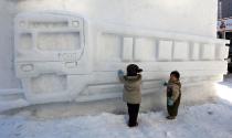 Children play with an ice sculpture ahead of the opening of the 60th Sapporo Snow Festival at Odori Park on February 4, 2009. The 60th Sapporo Snow Festival takes place from February 5 to 11, with more than 2 million tourists visiting the festival.