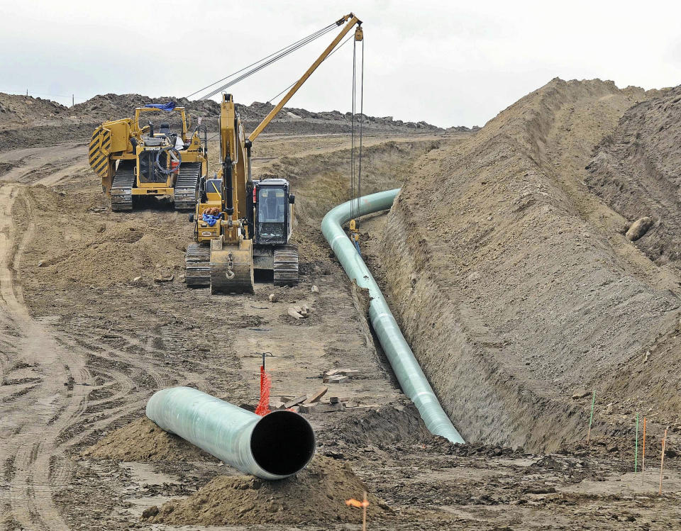 FILE - In this Oct. 5, 2016, file photo, heavy equipment is seen at a site where sections of the Dakota Access pipeline were being buried near the town of St. Anthony in Morton County, N.D. Environmentalists have filed a new legal challenge against a U.S. government program that allows oil and gas pipelines to be built across wetlands, rivers and other bodies of water. The lawsuit filed Monday, May 3, 2021, in U.S. District Court alleges the program lets companies skirt environmental reviews of potential spills (Tom Stromme/The Bismarck Tribune via AP)